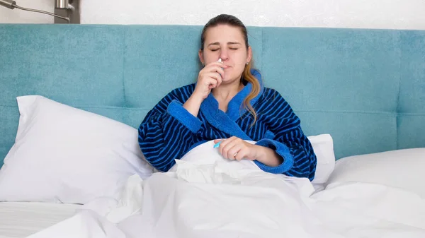 Portrét mladé ženy nemocné s rýma použití nosního spreje — Stock fotografie