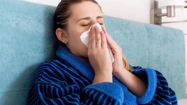 Potret closeup wanita muda merasa tidak sehat meniup hidung dalam jaringan kertas — Stok Foto