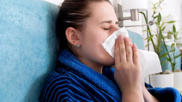 Zbliżenie Portret młodej kobiety chore z grypy dmuchanie Katar w papierowej chusteczki — Zdjęcie stockowe