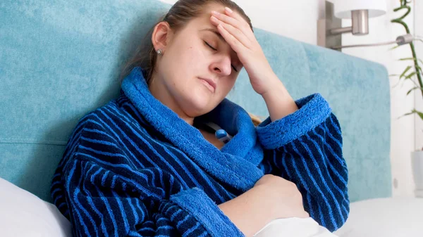 Retrato de close-up de mulher doente com feveer deitado na cama e segurando a mão na testa — Fotografia de Stock