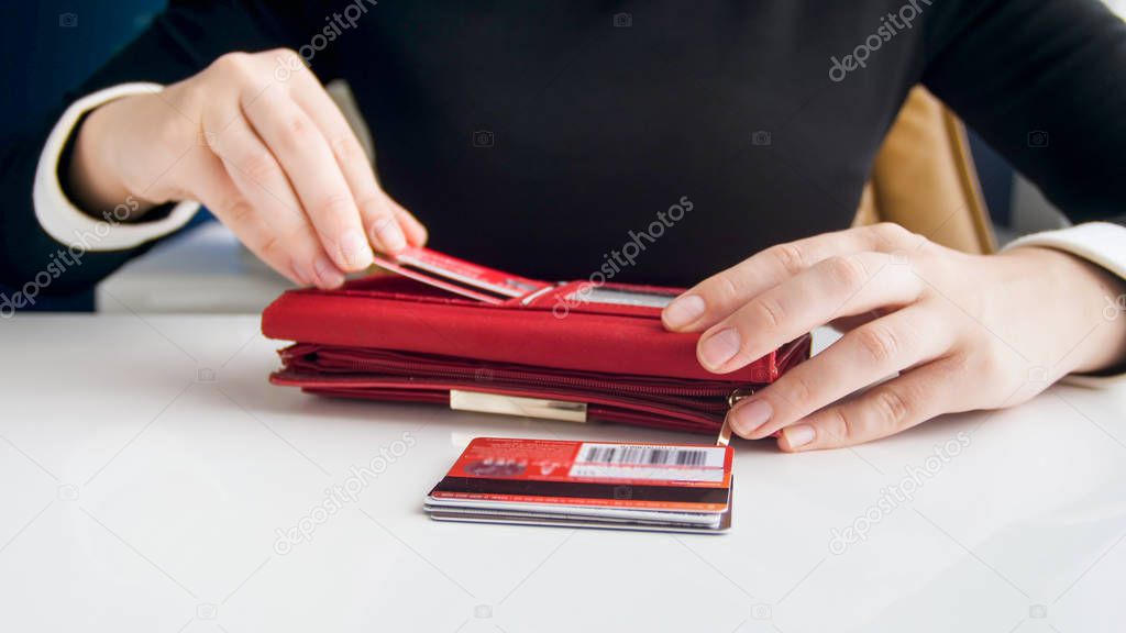 Closeup photo of businesswoman inserting credit card in leather purse