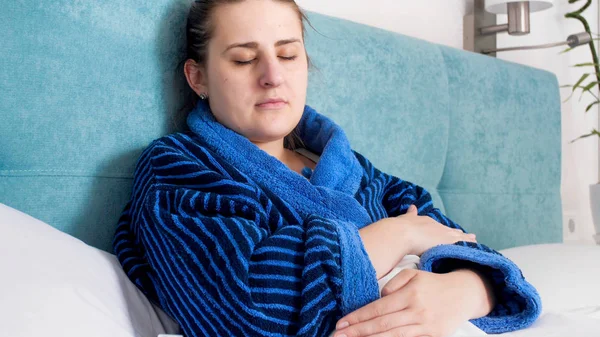 Retrato de mulher doente com febre deitada na cama e temperatura de medição — Fotografia de Stock