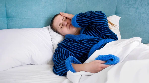 Retrato de mulher doente com dor de cabeça deitada na cama — Fotografia de Stock