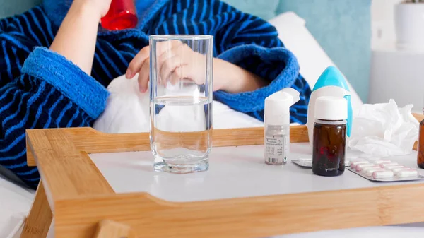 Κοντινό πλάνο εικόνα άρρωστο άτομο ξαπλωμένη στο κρεβάτι και χρησιμοποιώντας φάρμακα — Φωτογραφία Αρχείου