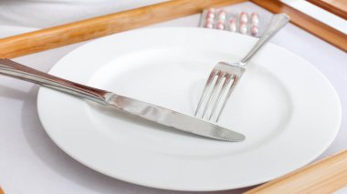 Portre resim çatal ve bıçak boş beyaz tabakta yalan. Diyet ve kilo verme kavramı