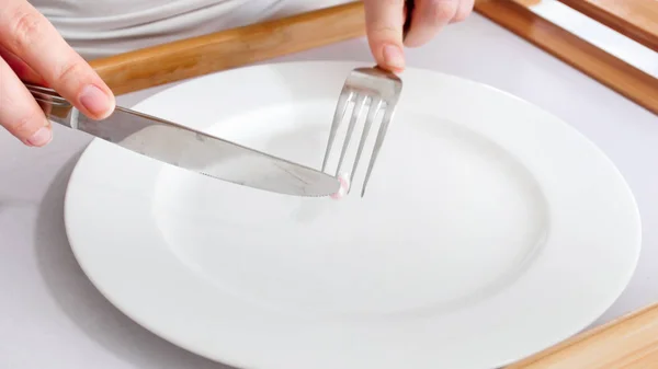 Closeup photo of woman eating from empty plate — Stock Photo, Image