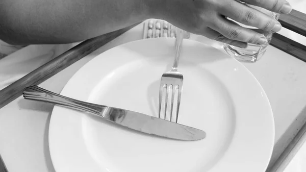 Closeup image of female hand holding glass of water after having dinner in bed — Stock Photo, Image