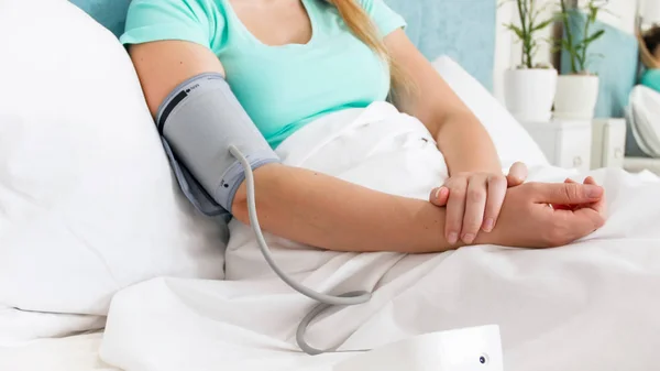 Detailní Foto mladá žena pocit nevolnosti měření krevního tlaku v posteli — Stock fotografie