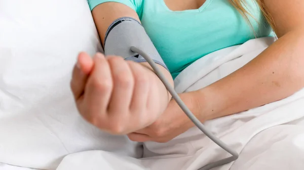 Detailní snímky nemocná žena ležela v posteli a měření krevního tlaku — Stock fotografie