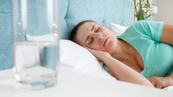 Retrato de mujer joven con camiseta azul durmiendo en la cama —  Fotos de Stock