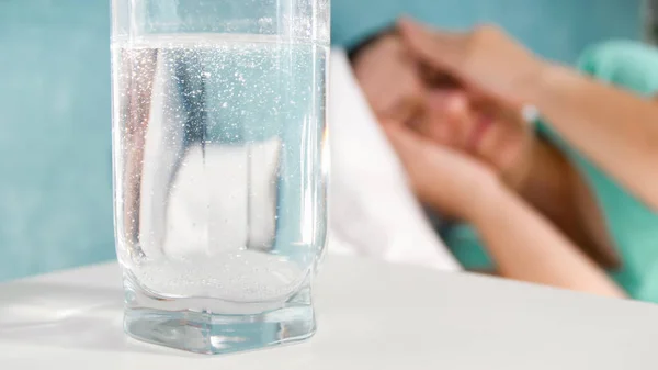 Foto tertutup dari gelas air dengan aspirin di meja samping tempat tidur — Stok Foto