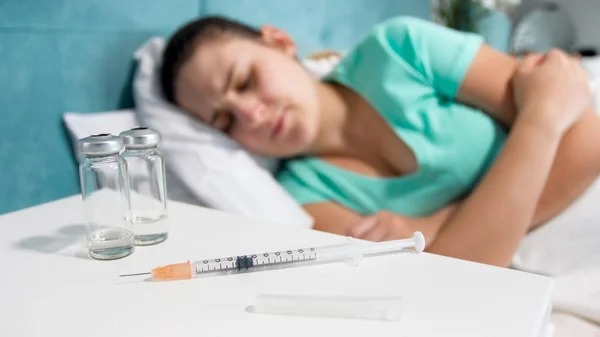 Közelkép kép fecskendő, a gyógyszerek és az ágyban fekvő beteg asszony — Stock Fotó