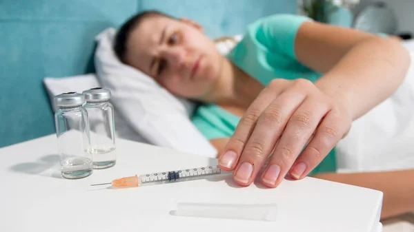 女性病人用注射器从床边桌上取药的特写照片 — 图库照片