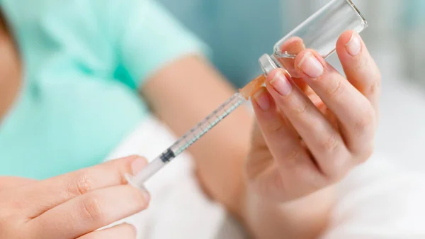 Closeup photo of young woman holding vial with medicines and syringe — Stock Photo, Image