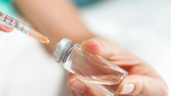 Image rapprochée d'une femme médecin remplissant la seringue avec des médicaments de l'ampoule — Photo