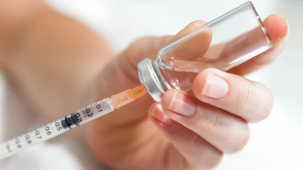 Macro image of nurse filling small syringe with drugs from vial — Stock Photo, Image