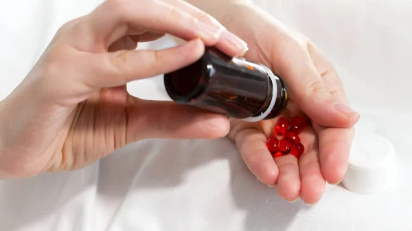 Close-up foto van jonge vrouw schudden van de fles met pillen en gieten hen aan kant — Stockfoto