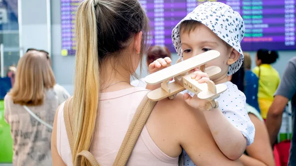 Image rapprochée du petit garçon tout-petit avec sa mère jouant dans le terminal de l'aéroport avant le vol — Photo