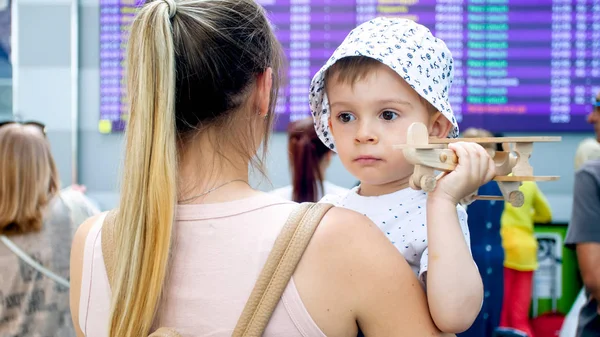 Portrait de jeune femme tenant son fils tout-petit et attendant son vol à l'aéroport — Photo