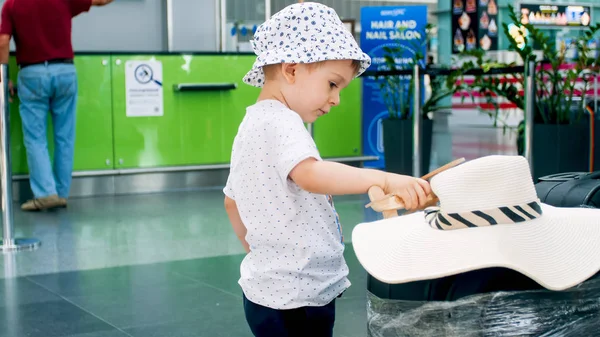 Tonas foto av söt småbarn pojke spelar i flygplatsterminalen — Stockfoto