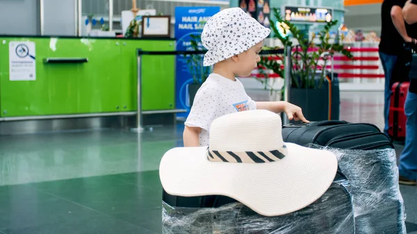 Portrait of little boy looking on suitcases in airport terminal — Stock Photo, Image