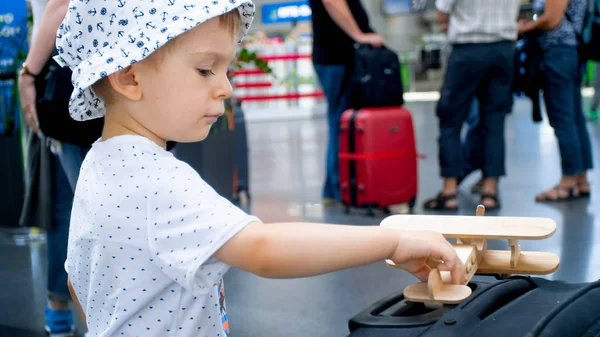Portrait de petit garçon avec avion jouet en bois à l'aéroport international — Photo