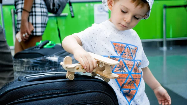 Portrait de garçon tout-petit mignon jouant avec un avion jouet en bois dans la ligne d'enregistrement — Photo