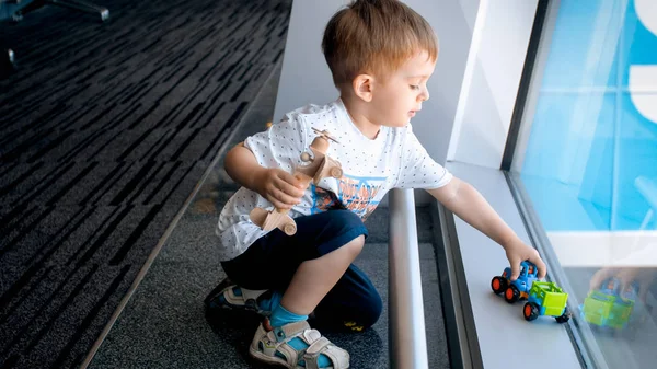 Śliczny maluch chłopak gra na podłodze w terminalu międzynarodowego lotniska — Zdjęcie stockowe