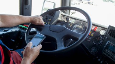 Portre fotoğraf erkek sürücünün smartphone otobüs sürüş sırasında holding