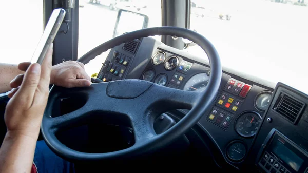 Foto in primo piano di un conducente irresponsabile con smartphone mentre guida un autobus pubblico. Pericolo in trasporto. Autista irresponsabile — Foto Stock