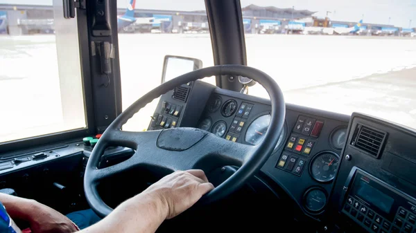 Imagen de primer plano del conductor que conduce el autobús de pasajeros hacia el avión en la pista — Foto de Stock