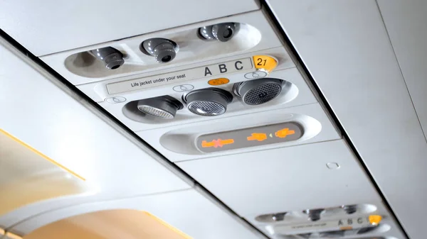 Close-up beeld van noodsituaties tekenen op het plafond van de passagier vliegtuig — Stockfoto