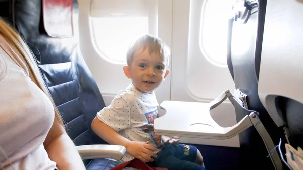 Retrato de niño sonriente feliz sentado en el asiento del avión — Foto de Stock