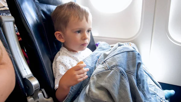 Retrato de niño sentado al lado del iluminador en el avión — Foto de Stock