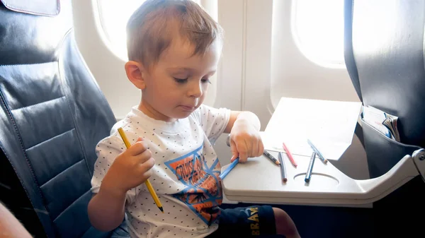 Retrato de niño pequeño con lápices de colores en el avión — Foto de Stock