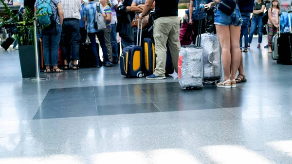 Ноги и чемодан на полу в международном терминале аэропорта — стоковое фото