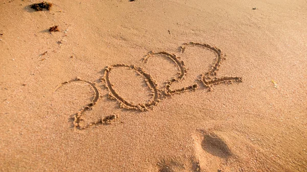 Imagen de primer plano de 2022 Números de Año Nuevo escritos en arena mojada en la playa — Foto de Stock