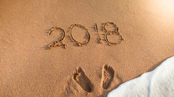 Bilden av 2018 nyår numrerar skriftligt på våt sandstrand. Begreppet nyår, jul och resa på vintersemester. — Stockfoto