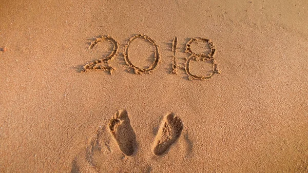 Närbild bild av 2018 nya året nummer skrivna på våt sand på stranden. Koncept för att fira och resa på sportlov. — Stockfoto