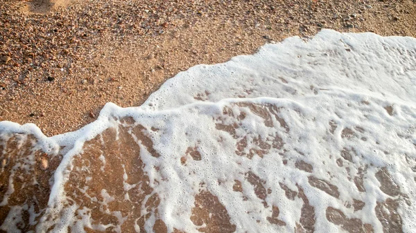 日落时，海浪在沙滩上翻滚的特写图像 — 图库照片