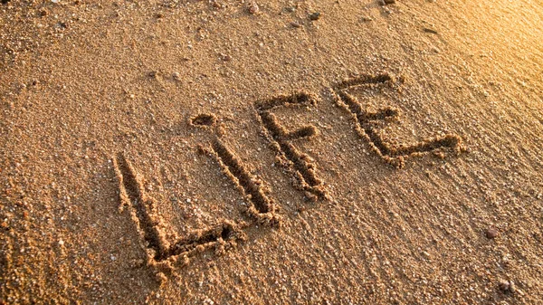 Foto de close-up da vida palavra inscrito na praia de areia — Fotografia de Stock