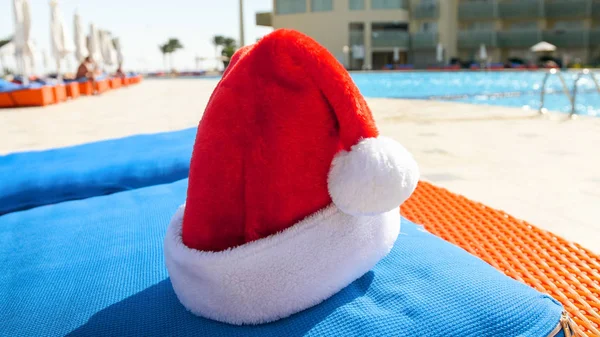 Foto in primo piano di Babbo Natale sdraiato sul materasso accanto alla piscina. Concetto di viaggio e turismo a Natale, Capodanno e vacanze invernali . — Foto Stock