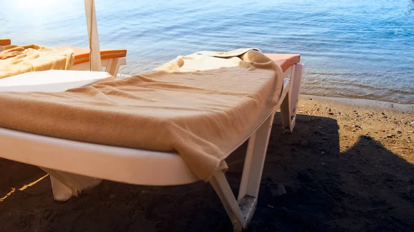 Close photo of chaise longs with beach towels on sea shore — Stock Photo, Image