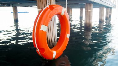 Plajda ahşap iskelede turuncu yaşam şamandırası görüntüsü