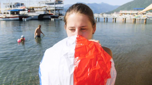 Zbliżenie Portret młodej matki pompowania piłki plażowej dla swojego dziecka na plaży — Zdjęcie stockowe