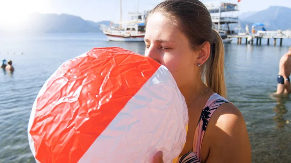 海で膨脹可能なビーチボールを持つ若い女性の肖像画 — ストック写真