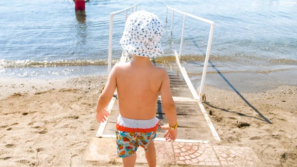 Imagem da visão traseira do menino criança caminhando no mar — Fotografia de Stock