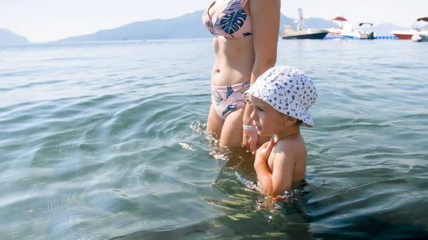 Little 3 years old toddler boy waling with mother in the sea water — Stock Photo, Image