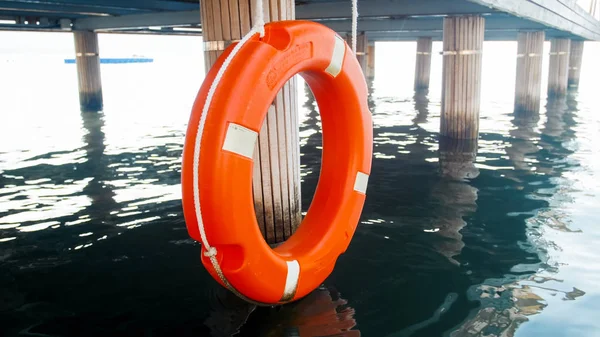 Närbild bild av orange Lifesaving boj hängande på lång träbrygga vid Sea Beach — Stockfoto