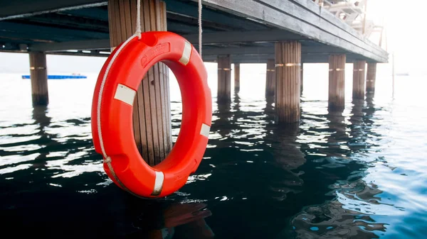 Image of orange life buoy on wooden pier at beach — Stock Photo, Image